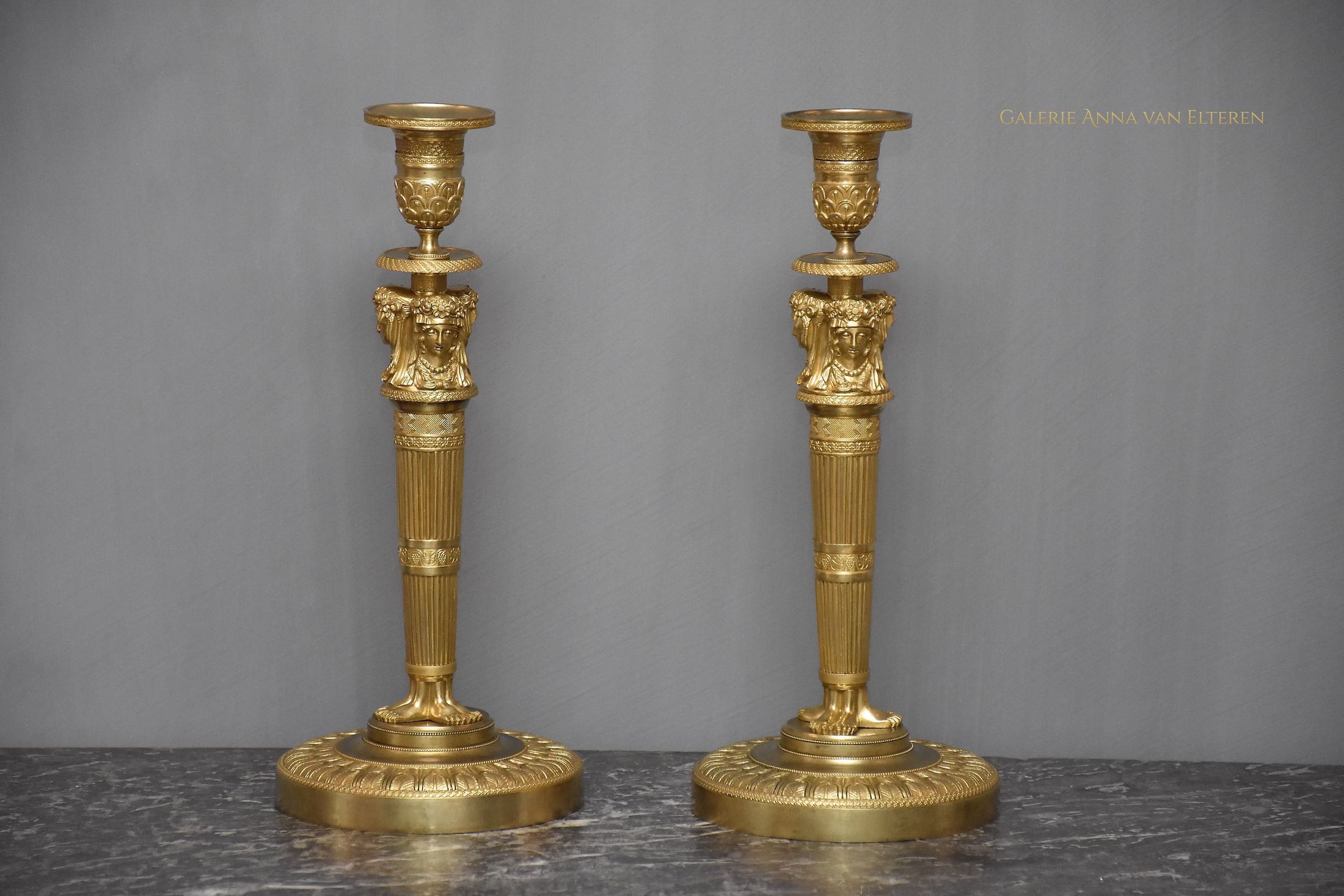 A pair of French Empire ormolu candlesticks